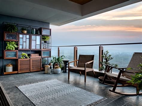 A Balcony With Rocking Chairs And Potted Plants On The Ledge