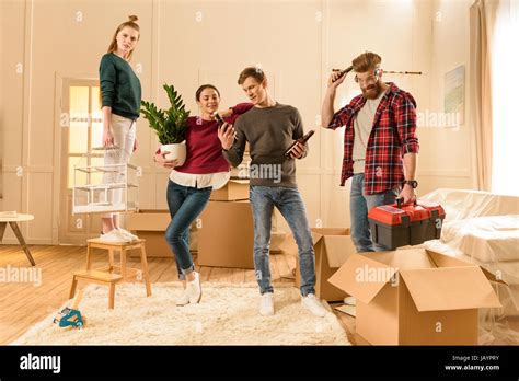 friends holding different things for moving into new house Stock Photo ...