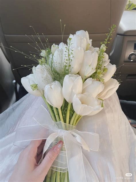 A Bouquet Of White Tulips Tied To A Ribbon In A Vase On The Back Seat