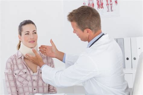 Doctor examinando al paciente con cuello ortopédico Foto Premium