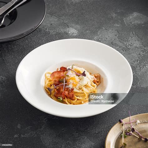 Classic Spaghetti Carbonara With Crispy Bacon And A Raw Egg Yolk Dusted