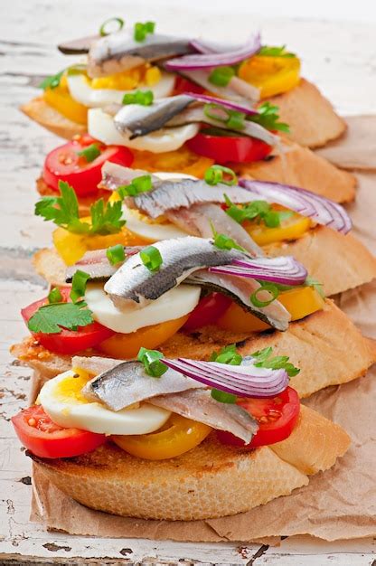 Crostini Con Anchoas Tomate Y Huevo Decorado Con Verduras Foto Premium