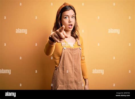 Jeune Belle Fille Blonde Portant Globalement Debout Sur Fond Isol Jaune Pointant M Content Et