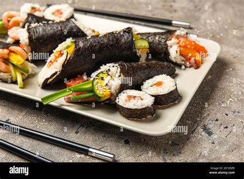 Plate With Tasty Sushi Cones And Rolls On Grunge Background Closeup