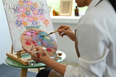 Cropped Image Of Female Artist Holding Palette And Painting Picture On