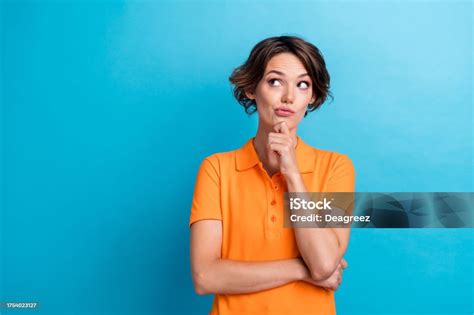 Photo Of Doubtful Unsure Lady Wear Orange Tshirt Arm Chin Looking Empty