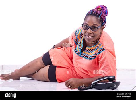 Beautiful Mature Woman Lying On The Floor With A Mobile Phone Smiling At The Camera Stock Photo