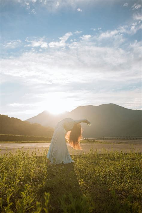 Woman In White Wedding Dress Standing On Green Grass Field · Free Stock