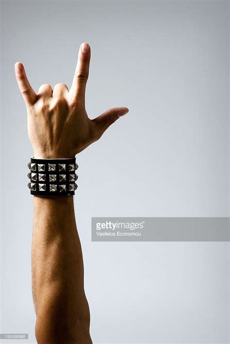 Close Up Of Man With Studded Wristband Making Rock Symbol Studio