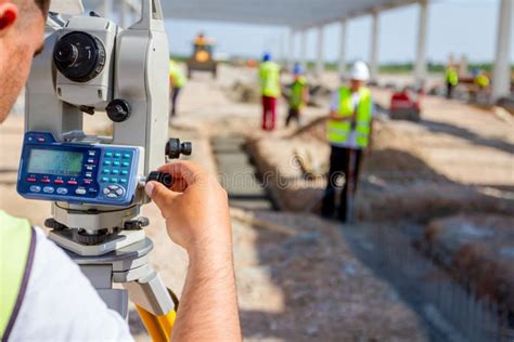 Civil Engineer Geodesist Is Working With Total Station On A Building