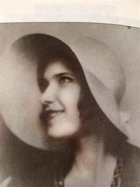 An Old Black And White Photo Of A Woman Wearing A Hat