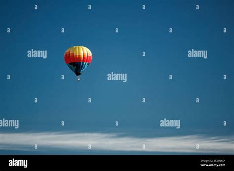 An Aerial View Of A Hot Air Balloon Against A Blue Sky Floating Over The Idaho Country Side