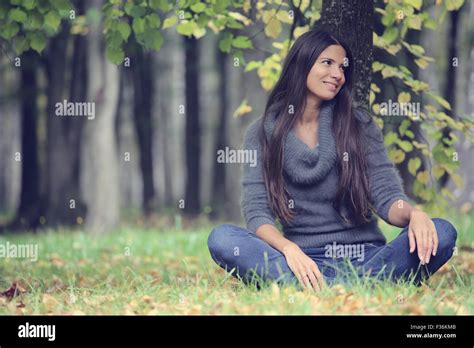 Beautiful Brunette Woman Sitting Under The Tree In Autumn Park Stock Photo Alamy