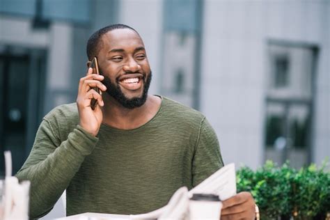 Homem feliz falando no telefone no café Foto Grátis