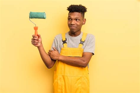 Joven afro negro encogiéndose de hombros sintiéndose confundido e