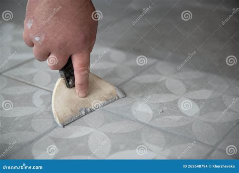 Tiler Laying The Ceramic Tile On The Floor Professional Worker Makes