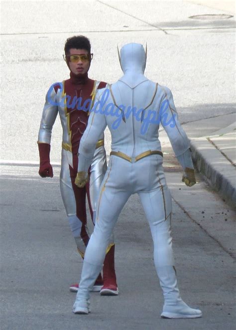 Two Men In White And Red Costumes Walking Down The Street