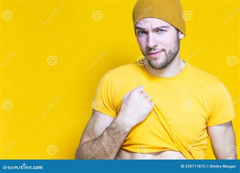 Serious Caucasian Handsome Man In Yellow Tshirt Posing In Warm Hat Over