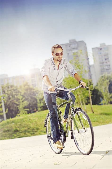 Homem Novo Que Estaciona Sua Bicicleta Na Rua Da Cidade Foto De Stock