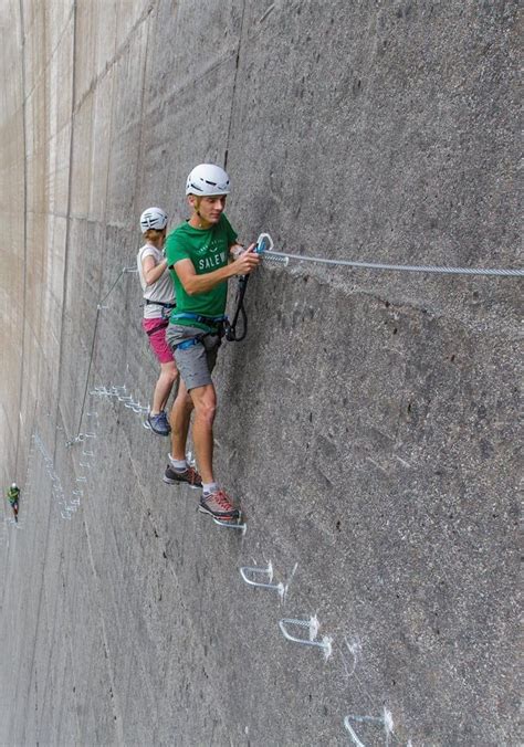 Two People Climbing Up The Side Of A Rock Wall With Chalk Writing On It