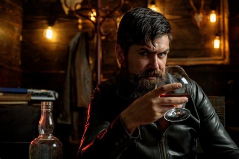 Premium Photo Man With Beard Holds Glass Brandy Macho Drinking