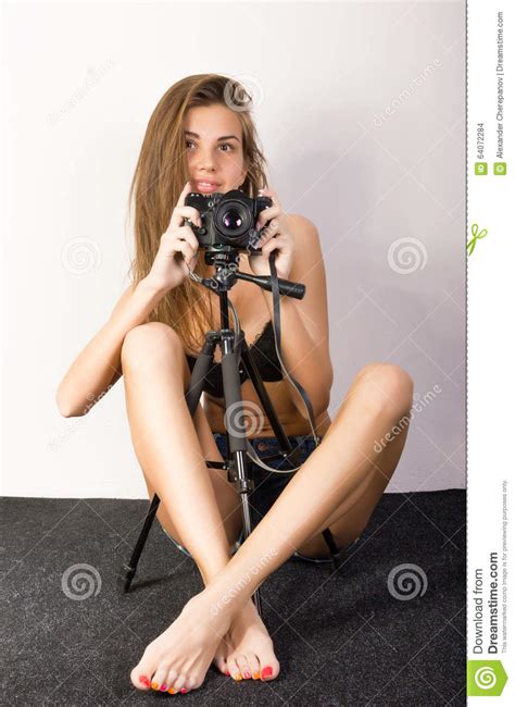 Beautiful Smiling Brunette Girl With A Camera Sits On A Soft Floor Stock Photo Image Of