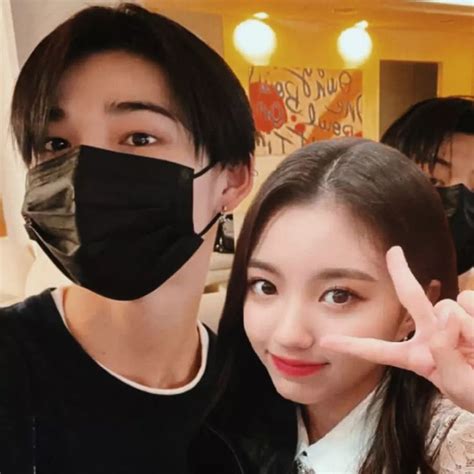 Two People Wearing Face Masks And Making The Peace Sign With Their