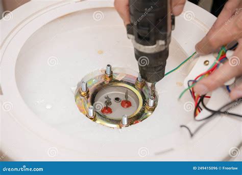 A Man Taking Apart The Tank Of An Electric Water Heater Stock Photo