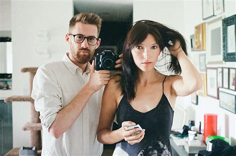 Young Couple Taking A Self Portrait In The Mirror By Stocksy