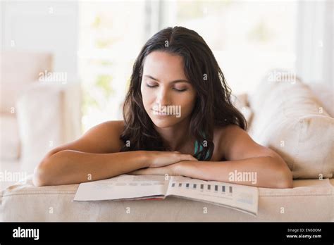 Pretty Brunette Reading Magazine On The Couch Stock Photo Alamy