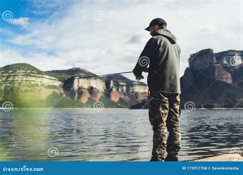 Fisherman Enjoy Hobby With Fishing Rod On River Beard Person Catch