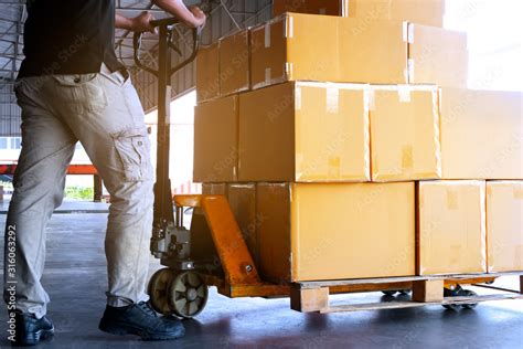 Workers Unloading Packaging Boxes On Pallets In The Warehouse Cartons