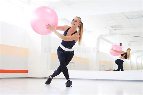 Mujer Sonriente Que Hace Ejercicio Con Los Fitballs En El Cuarto De La