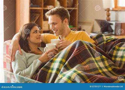 Young Couple Cuddling On The Couch Under Blanket Stock Image Image Of