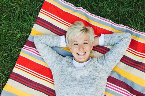 Blonde Woman Lying Outside By Stocksy Contributor BONNINSTUDIO Stocksy