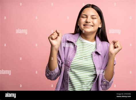 Happy Joyful Teenage Amazed Brunette Girl Clenching Fists With Closed