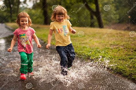 Kids Jumping Into Water Puddle Stock Image Image Of Playing Dirty