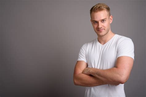 Premium Photo Young Handsome Man With Blond Hair Against Gray