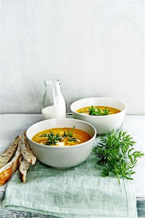 Two Bowls Filled With Soup Next To Bread