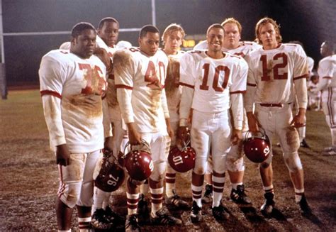 A Group Of Men Standing Next To Each Other On Top Of A Field Wearing