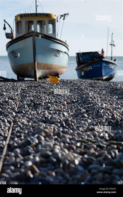 Two Fishing Boats Rest On The Shingle Beach At Beer In Devon Stock