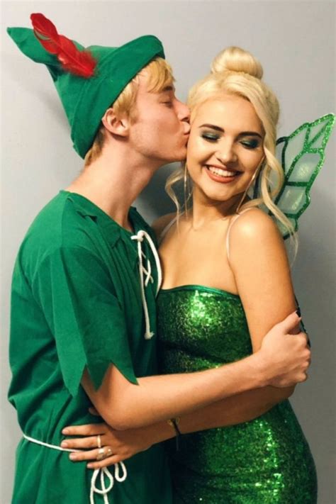 A Man And Woman Dressed Up As Tinkerbells Kissing On The Cheek While