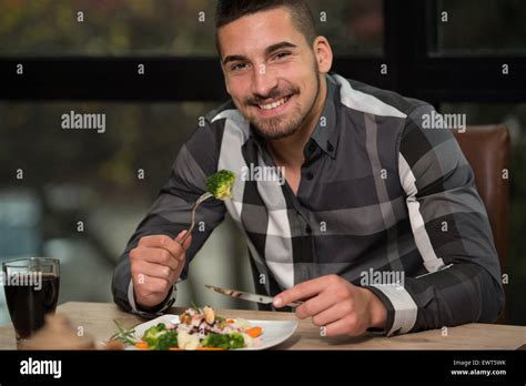 Handsome Man Eating At A Restaurant And Looking Happy Stock Photo Alamy