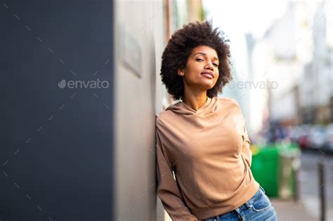 African American Beautiful Woman Leaning Against Wall Outside Stock