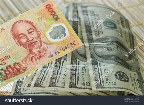 Vietnamese Dong In The Front With A Few Hundred Dollar Bills In The