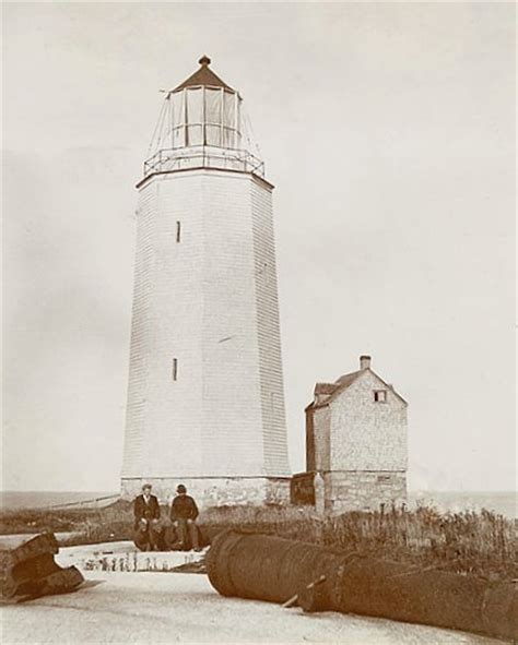 Sambro Island Lighthouse, attached shed, cannons and two men (1901)