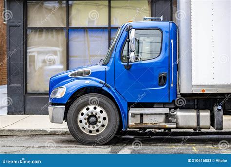 Blue Middle Duty Day Cab Semi Truck With Box Trailer Standing On The City Street Making Delivery