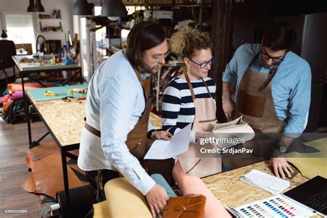 At Workshop Caucasian Male And Female Tailors Working On A New