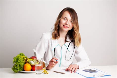 Young Dietitian Doctor At The Consulting Room At The Table With Fresh