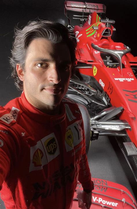 A Man Standing Next To A Red Race Car